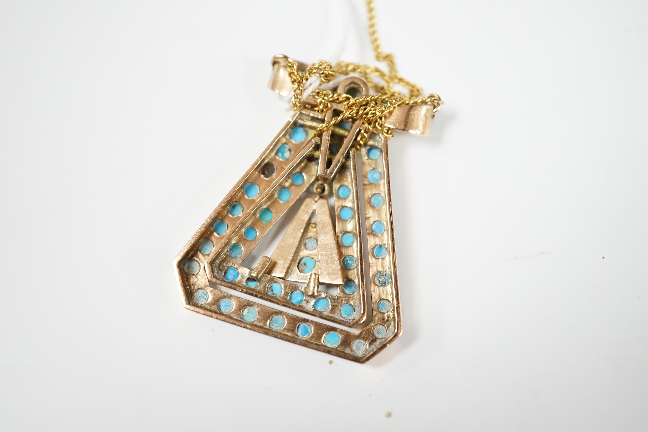 A yellow metal and turquoise cluster set triangular pendant, with ribbon bow terminal, 43mm, on a yellow metal chain. Condition - fair